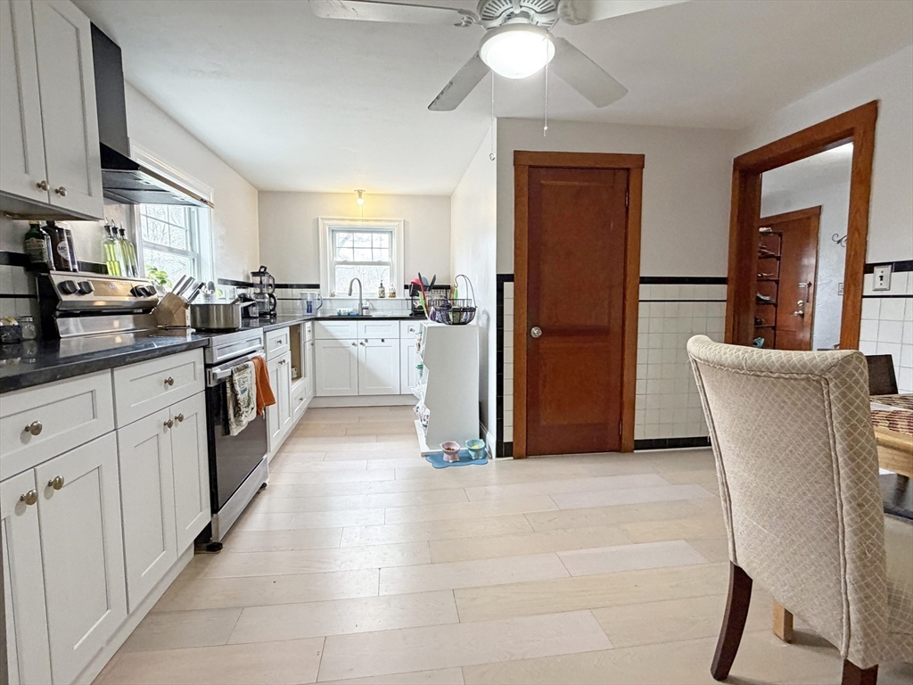 75-77 Dale Street, Unit 77 Waltham, MA 02451 - Photo 9 of 17 a kitchen with stainless steel appliances granite countertop a refrigerator sink and cabinets