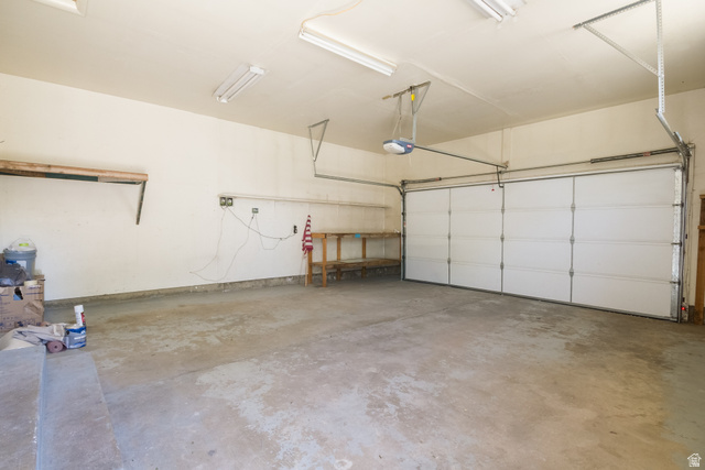 634 South 2100th Street West Vernal, UT 84078 - Photo 47 of 71 Integrated garage space featuring a concrete floor, overhead fluorescent lighting, and an automatic garage door opener