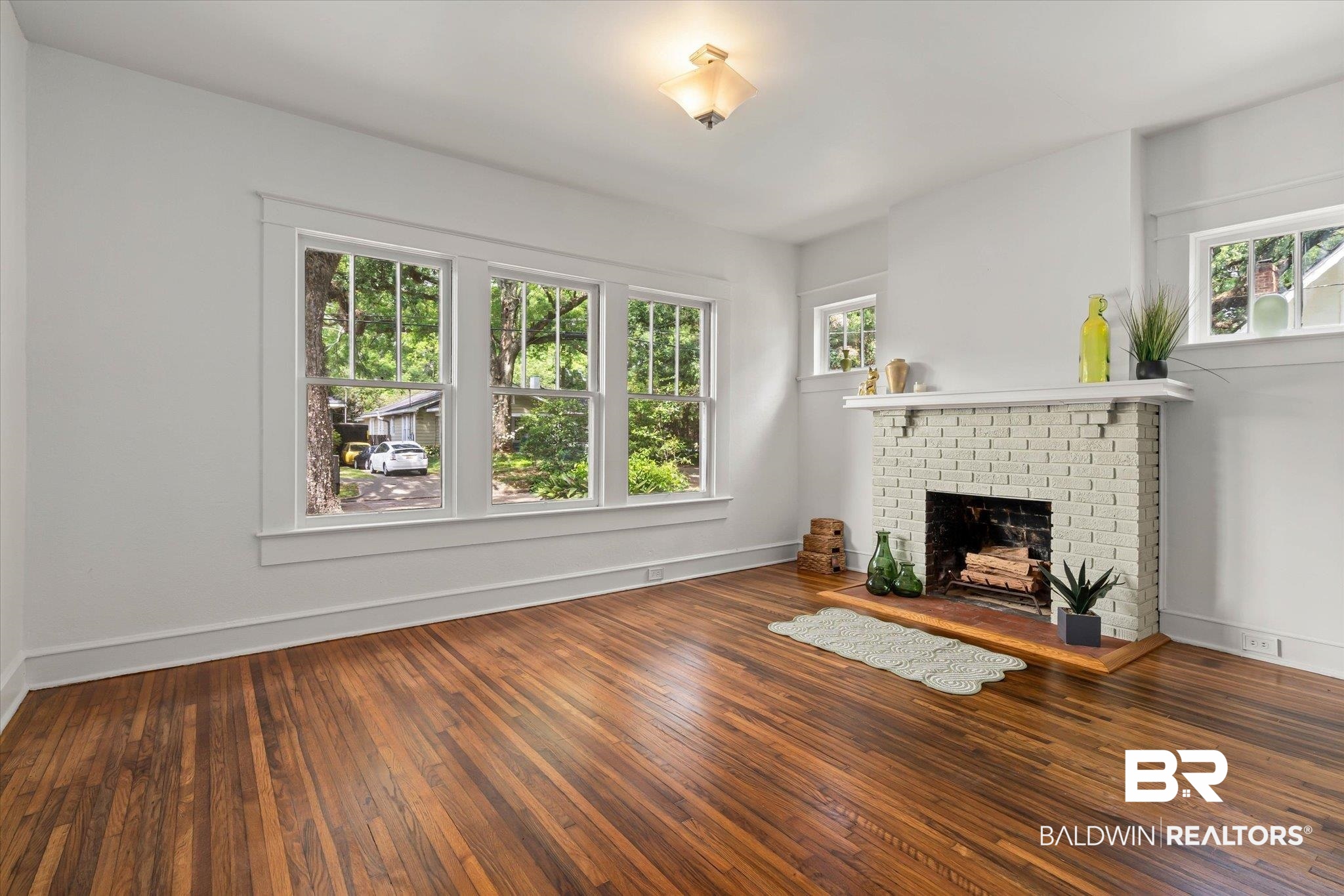 121 Westwood Street Mobile, AL 36606 - Photo 4 of 20 Unfurnished living room with wood-type flooring, baseboards, and a brick fireplace