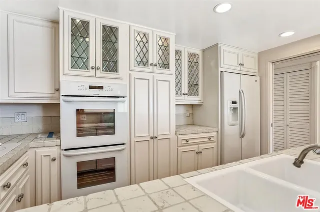 a view of a kitchen with a sink and refrigerator