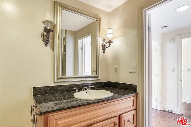 a bathroom with a granite countertop sink and a bathtub