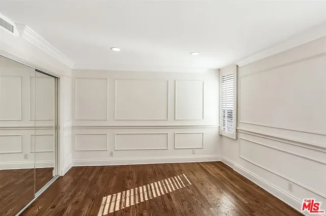 a view of empty room with wooden floor and cabinet