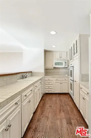 a kitchen with granite countertop white cabinets stainless steel appliances and a sink