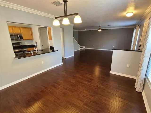a view of a kitchen with a sink wooden floor and a living room