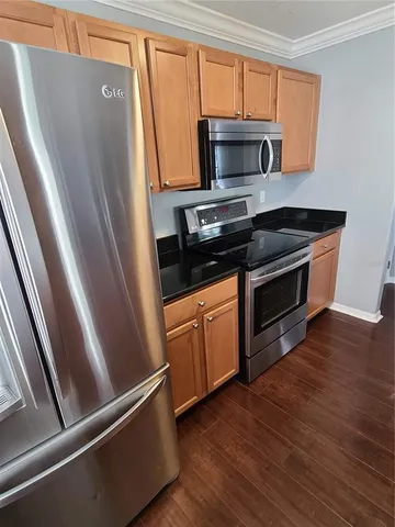 a kitchen with granite countertop a refrigerator stove and microwave