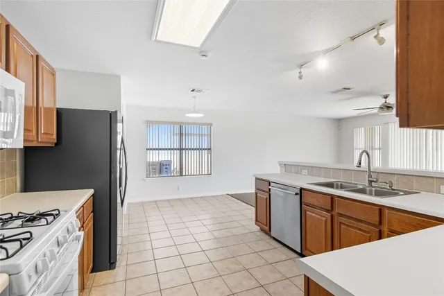 a kitchen with stainless steel appliances granite countertop a sink stove and refrigerator
