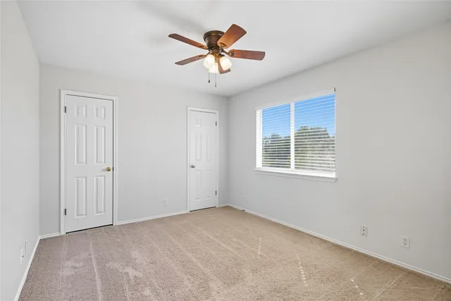 a view of a livingroom with a ceiling fan and window