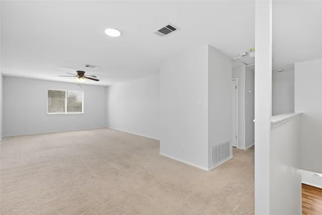 a view of a livingroom with a ceiling fan and window