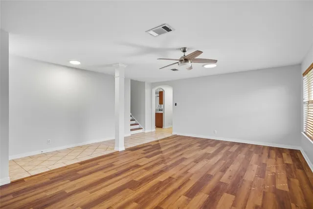 a view of a room with wooden floor and ceiling fan