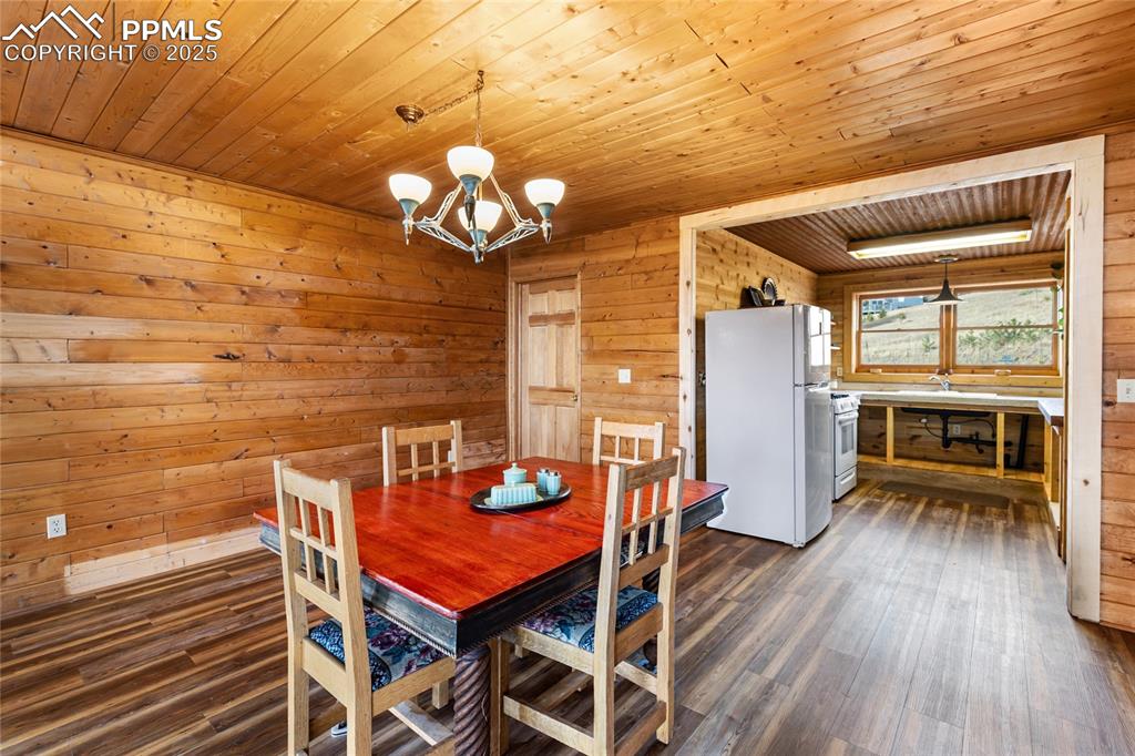 795 South Mountain Estates Road Florissant, CO 80816 - Photo 13 of 42 a view of a dining room with furniture a chandelier and wooden floor