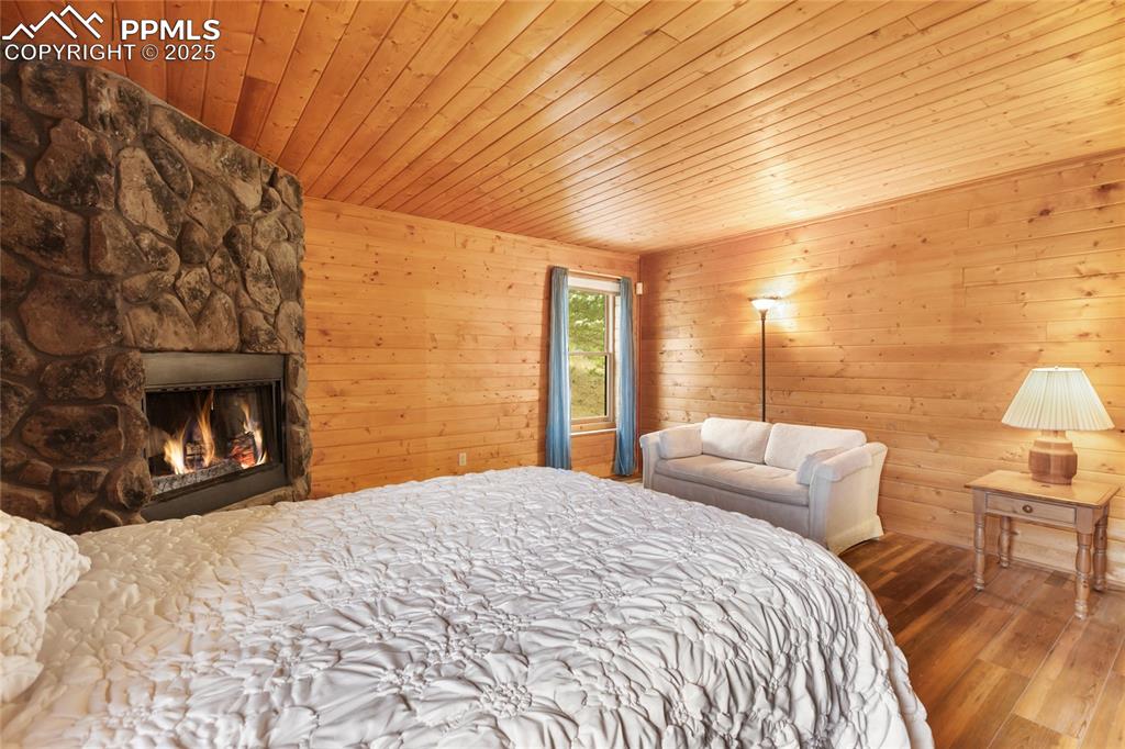 795 South Mountain Estates Road Florissant, CO 80816 - Photo 18 of 42 a bedroom with a bed and a lamp on dresser
