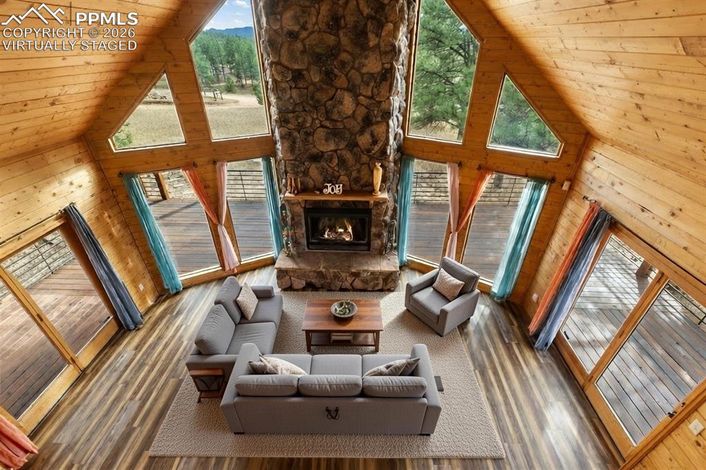 795 South Mountain Estates Road Florissant, CO 80816 - Photo 26 of 42 a living room with furniture a large window with wooden floor