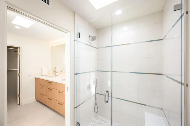 a bathroom with a double vanity sink a vanity and a shower
