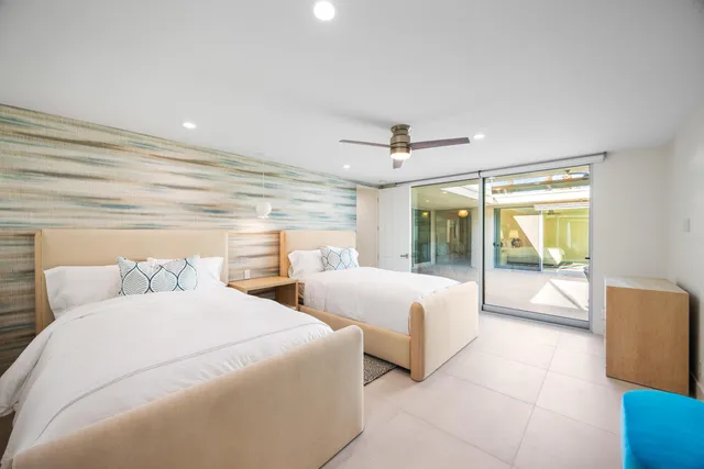 a spacious bedroom with two large bed and a large window