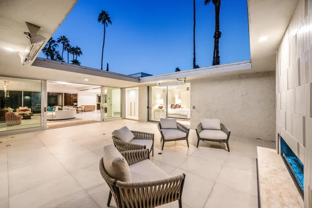 a living room with furniture a rug and white walls