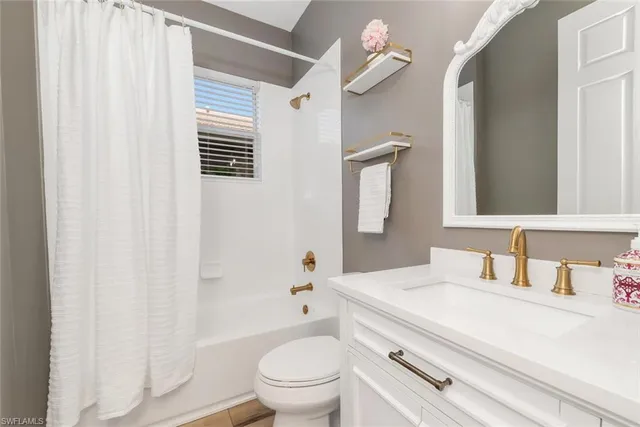 a bathroom with a sink a toilet a mirror and shower