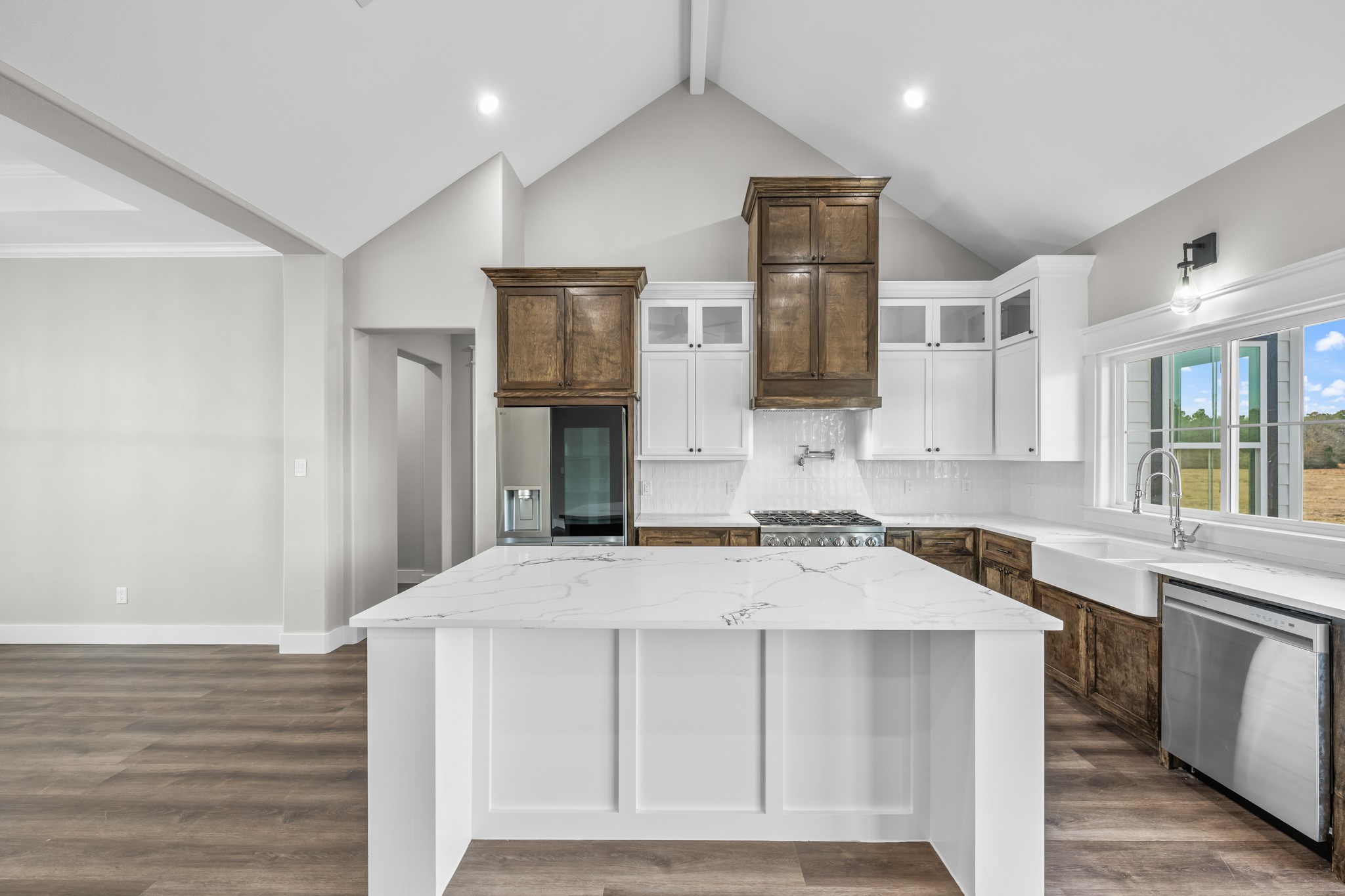 93 Longhorn Loop New Waverly, TX 77358 - Photo 11 of 47 a kitchen that has a sink a microwave oven a stove and white cabinets with wooden floor