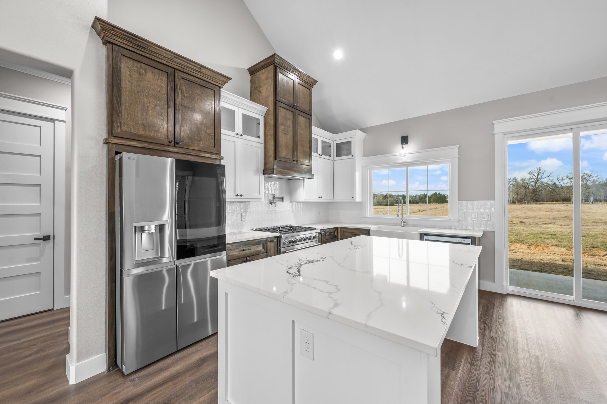 93 Longhorn Loop New Waverly, TX 77358 - Photo 15 of 47 a kitchen with stainless steel appliances granite countertop a refrigerator a sink and a stove with wooden floor