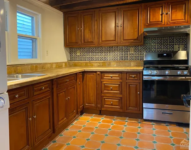 a kitchen with granite countertop a sink stove and cabinets