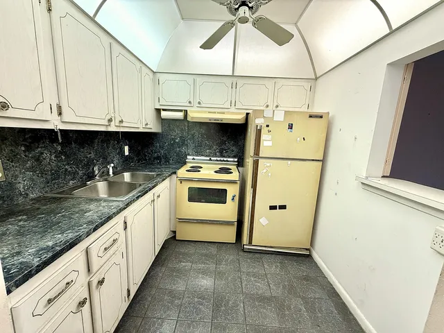 a kitchen with cabinets and white appliances