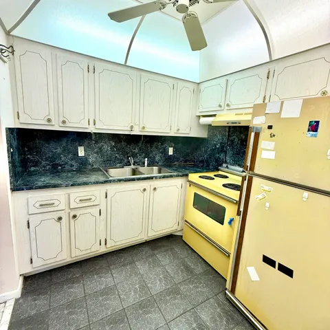a kitchen with white cabinets and white appliances