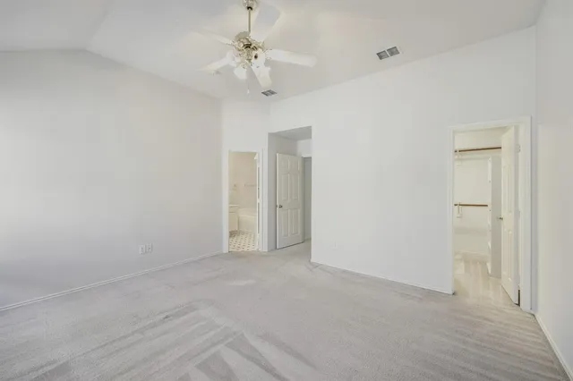 a view of an empty room with a chandelier fan