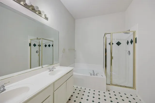 a bathroom with a bathtub sink vanity and mirror