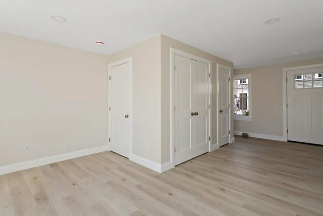 a view of a hallway with wooden floor and closet area