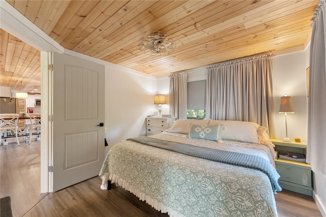 30 Mobleys Bluff Road Abbeville, SC 29620 - Photo 17 of 35 Natural wood ceilings and durable laminate flooring create a warm atmosphere in this comfortable bedroom.