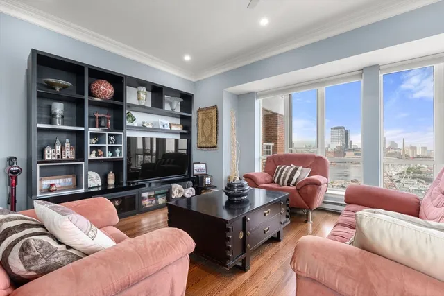 a living room with furniture a large window and a flat screen tv