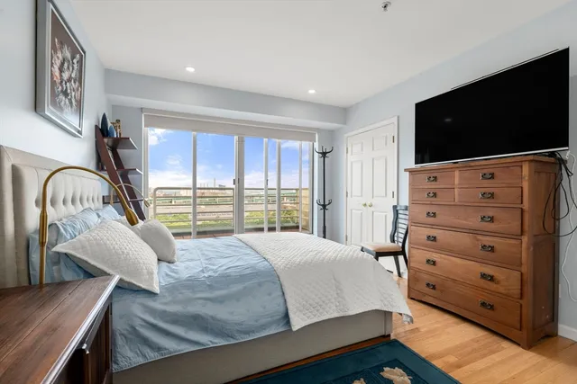 a bedroom with a bed and a flat tv screen on dresser