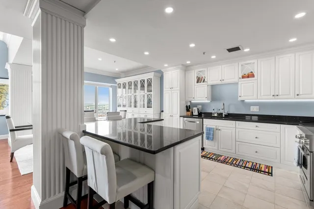 a kitchen with stainless steel appliances granite countertop a table chairs sink and cabinets