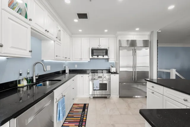 a kitchen with stainless steel appliances granite countertop a sink stove and refrigerator