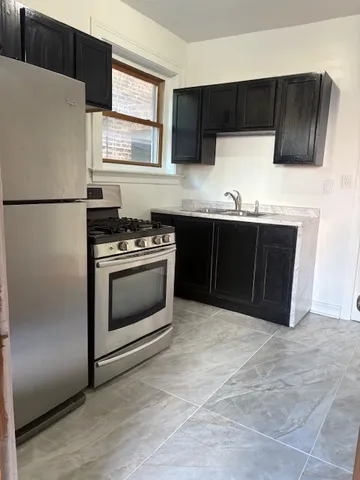 a kitchen with granite countertop a stove a refrigerator and a sink