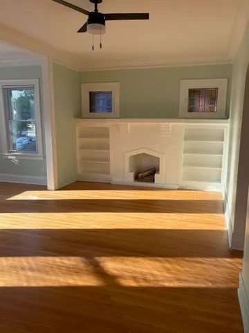 a view of a livingroom with a ceiling fan and wooden floor