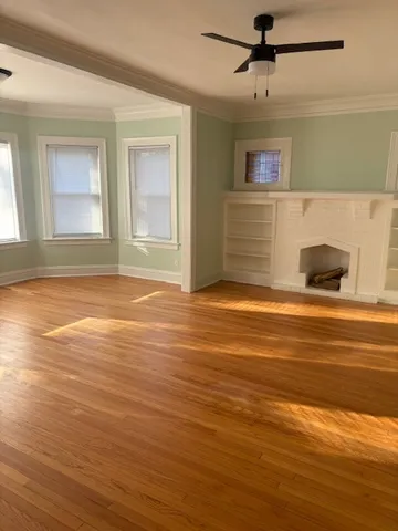 a view of empty room with window and wooden floor