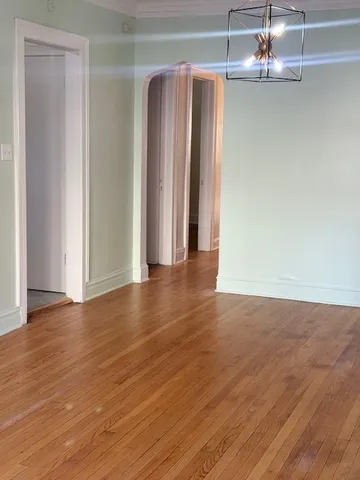 a view of a room with wooden floor and chandelier