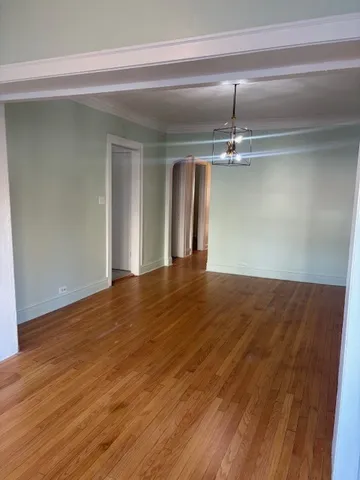 a view of a room with wooden floor and chandelier