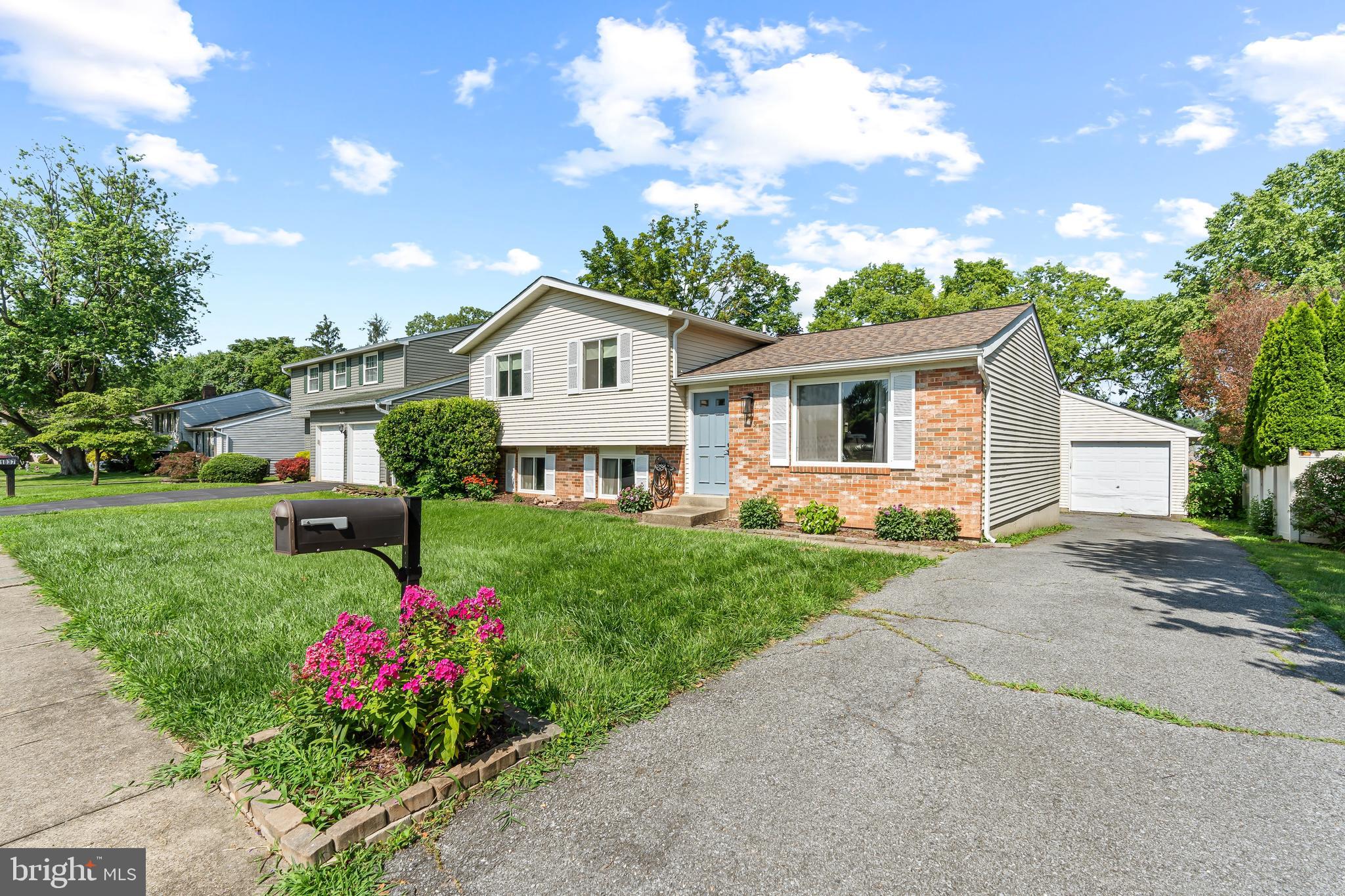 1839 Lawnview Drive Frederick, MD 21702 - Photo 4 of 42 a front view of a house with a yard and fountain in middle of green field