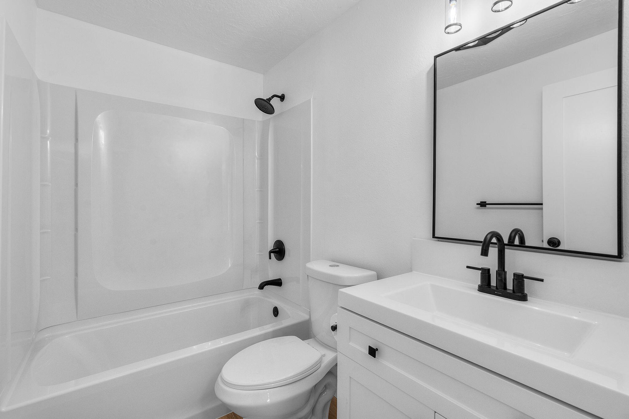 1700 Northeast Wells Acres Road, Unit 25 Bend, OR 97701 - Photo 20 of 25 a bathroom with a sink a toilet a mirror a bathtub and shower