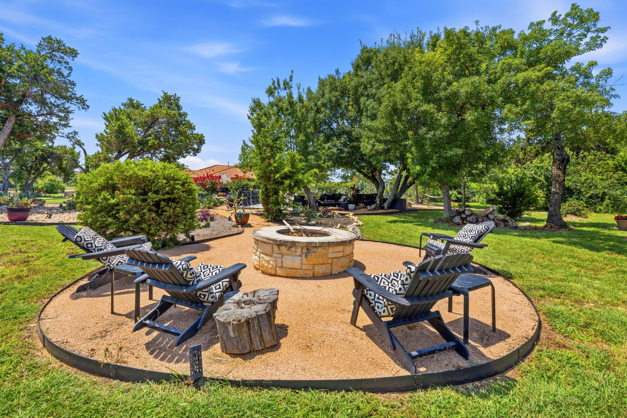 816 Brave Face Street Leander, TX 78641 - Photo 35 of 40 An inviting stone fire pit area is perfectly positioned for relaxation amidst the well-maintained backyard.