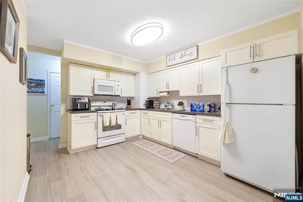 344 Prospect Avenue, Unit 4C Hackensack, NJ 07601 - Photo 11 of 19 a kitchen with white cabinets and white appliances