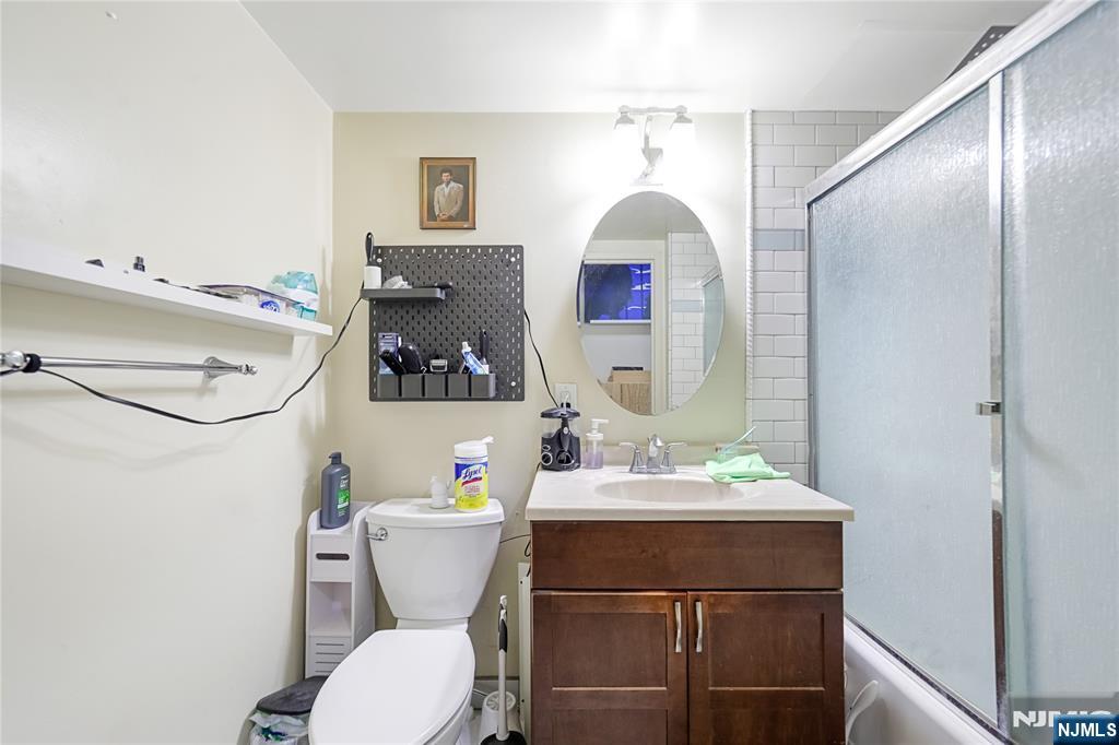 344 Prospect Avenue, Unit 4C Hackensack, NJ 07601 - Photo 12 of 19 a bathroom with a sink vanity mirror and toilet