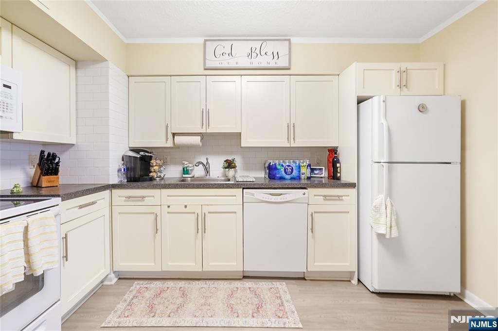 344 Prospect Avenue, Unit 4C Hackensack, NJ 07601 - Photo 10 of 19 a kitchen with stainless steel appliances white cabinets and a refrigerator