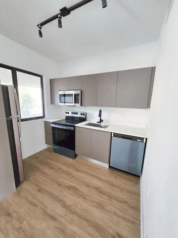 a view of a kitchen with a sink and a refrigerator