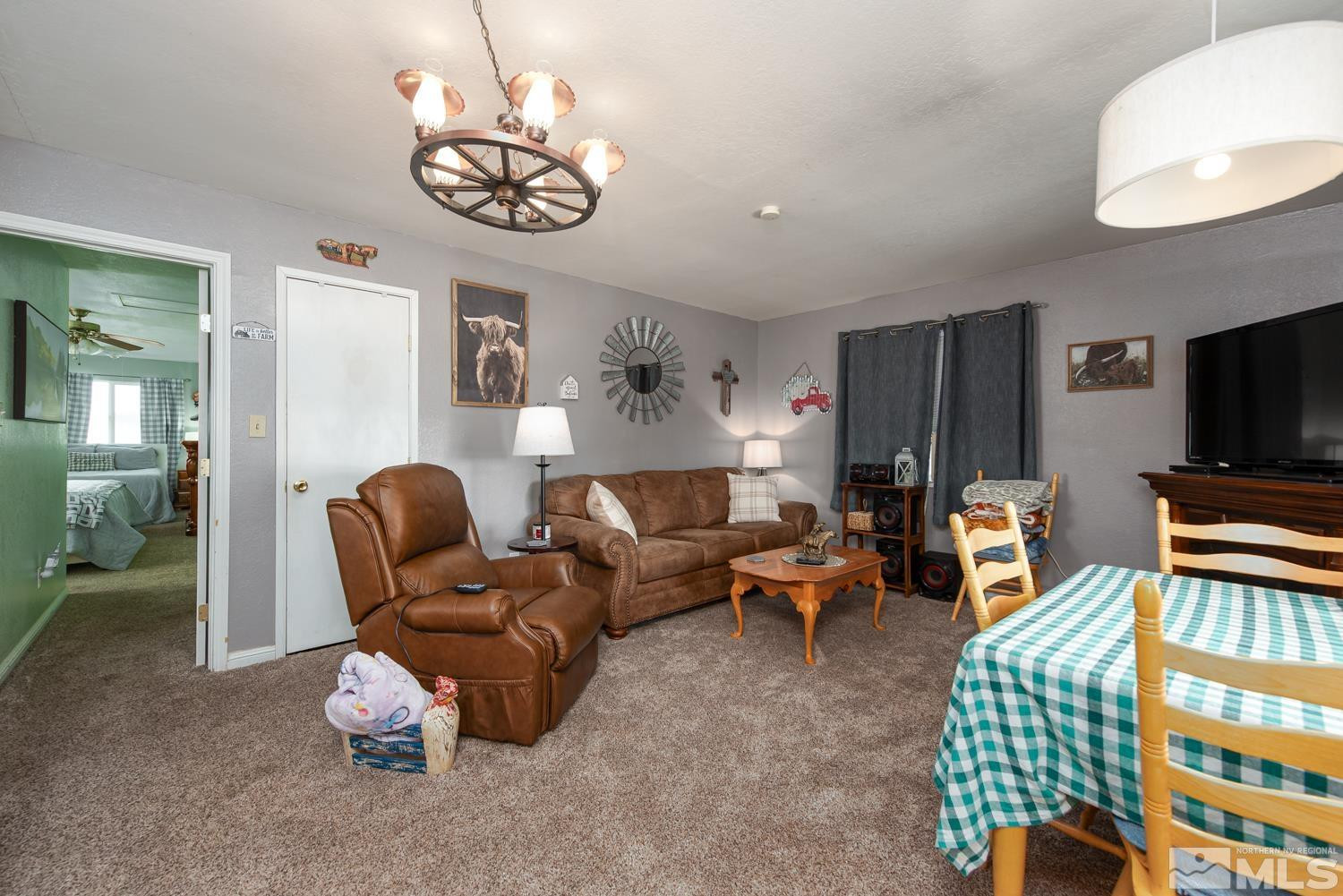50 Miller Ridge Road Smith Valley, NV 89444 - Photo 49 of 51 a living room with furniture a chandelier and a flat screen tv