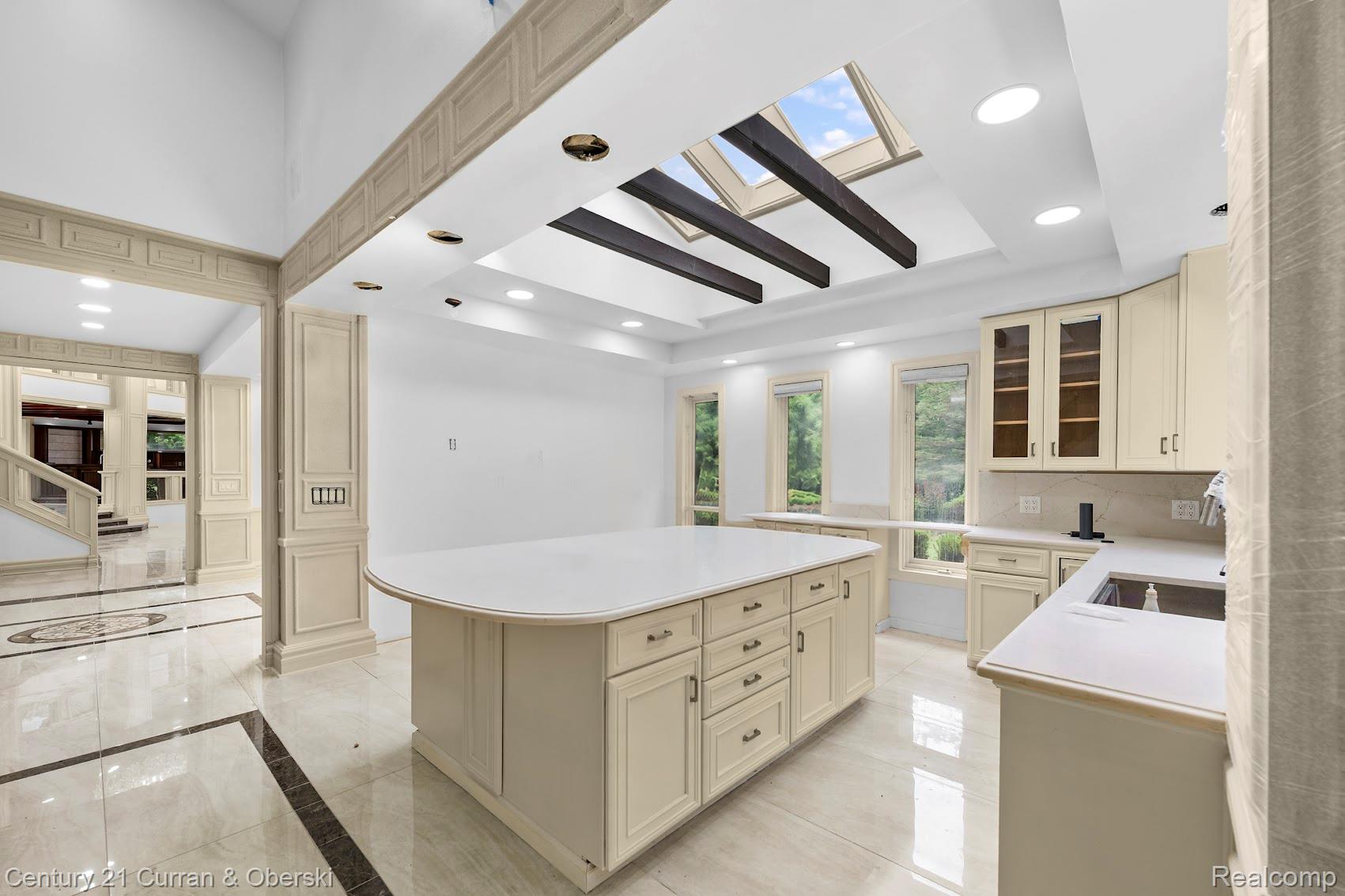 8785 Warren Road Plymouth, MI 48170 - Photo 15 of 46 Spacious kitchen featuring a large central island with light cabinetry, skylights, recessed lighting, and a windowed backsplash