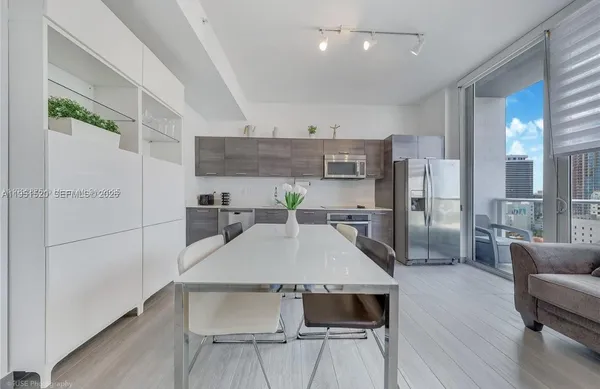 a view of a kitchen with kitchen island a counter top space a sink stainless steel appliances and cabinets