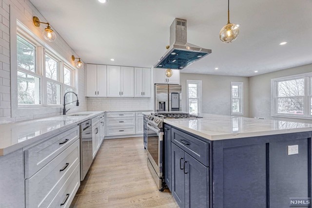 a kitchen with stainless steel appliances granite countertop a sink a stove and a window