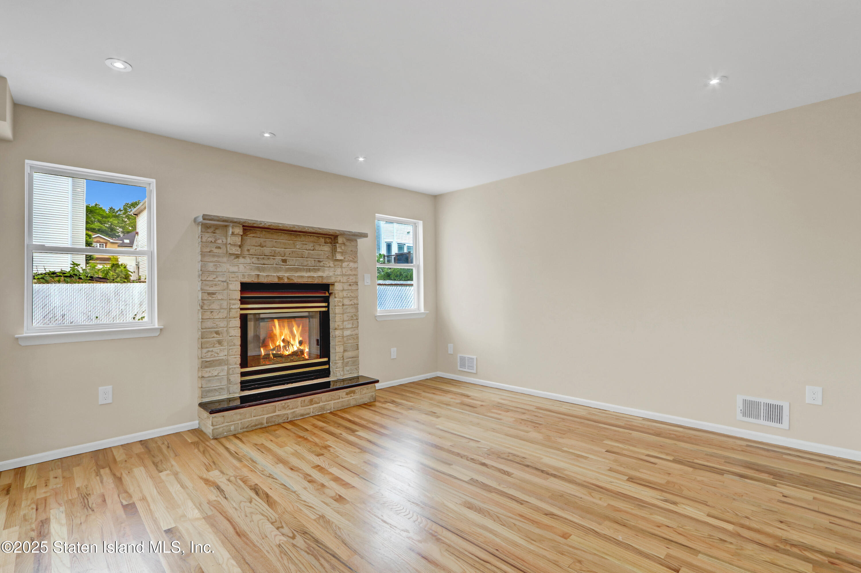 103 Savo Loop Staten Island, NY 10309 - Photo 14 of 46 an empty room with wooden floor fireplace and windows